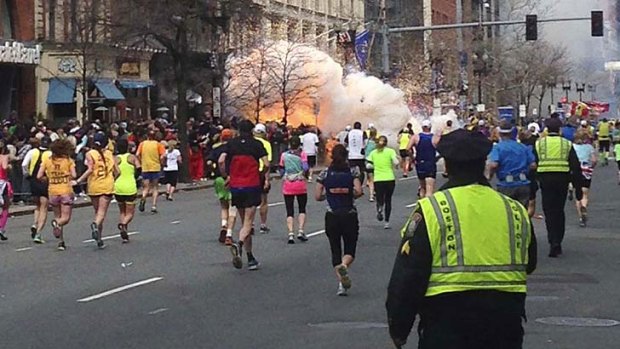 Tragedy: Runners continue to run towards the finish line of the Boston Marathon as an explosion erupts.