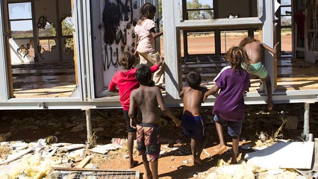 Destroyed: Children play in the wrecked demountable that was supposed to be the new community centre.