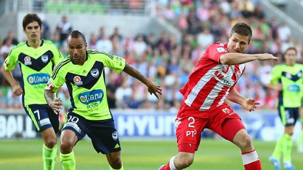 Michael Marrone (right) challenges Victory's Archie Thompson during the Melbourne derby last month.