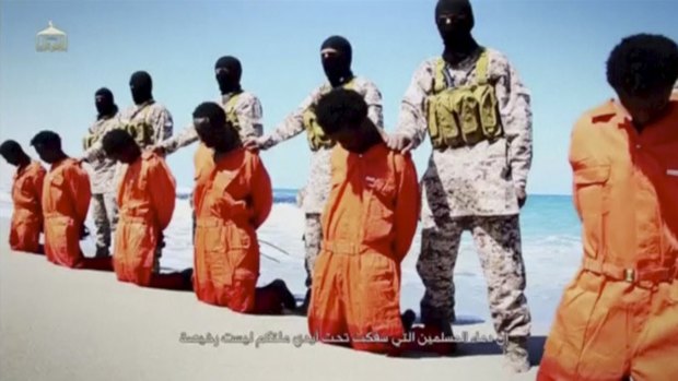 Islamic State militants stand behind what are said to be Ethiopian Christians along a beach in Wilayat Barqa.