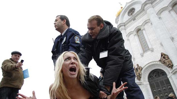 Security guards detain an activist from women's rights group Femen.