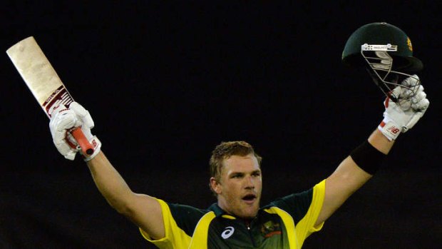 Australian batsman Aaron Finch celebrates scoring a century during the first one-day international match of the series against England in Melbourne.