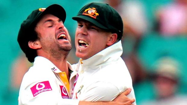 David Warner (R) is embraced by Ed Cowan after catching Indian opener Gautam Gambhir at point from the bowling of Peter Siddle.