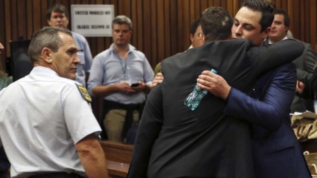 Oscar Pistorius hugs his brother Carl Pistorius in court.
