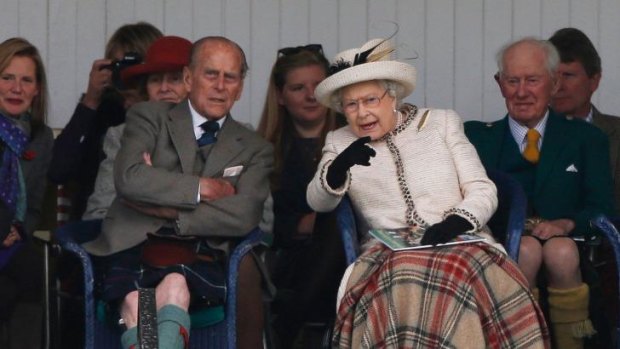 Queen Elizabeth and Prince Philip watch the caber being tossed at the annual Braemar Highland Gathering in Braemar, Scotland.