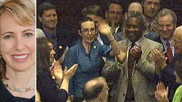 Cheering lawmakers greet Ms Giffords as she returned to the House of Representatives today. Left: Ms Giffords before she was gunned down.