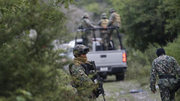 Soldiers of the Mexican Navy stand guard near a newly discovered mass grave outside the mountain town of Cocula.