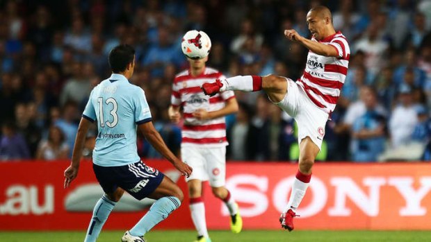 City divided: (left) Wanderers marquee man Shinji Ono leaps to boot the ball downfield against Sydney FC at Allianz Stadium.