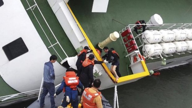 Contentious moment ... South Korean coast guard officers rescue ferry Sewol captain Lee Joon-seok, wearing a sweater and underwear, from the ferry in the water off the southern coast near Jindo, South Korea.