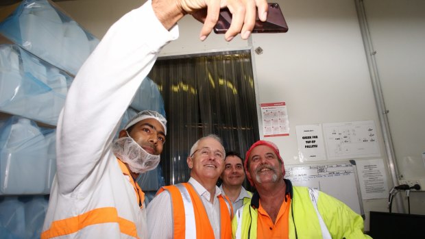 Prime Minister Malcolm Turnbull poses for a selfie with workers at  Grove Fruit Juice in Brisbane.