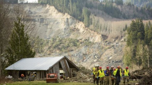 Rescue workers at one of the number of homes that were wrecked by the mudslide.