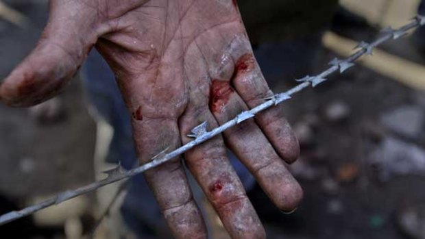 As a show of pride, a man uses his bare hands to remove razor-wire at the barricades set up in Cairo's Tahrir Square.