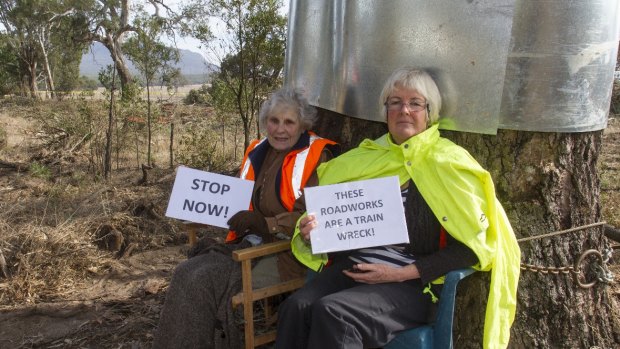 Isabel Mackenzie, left, has locked herself to a rover red gum in protest at its slated removal.