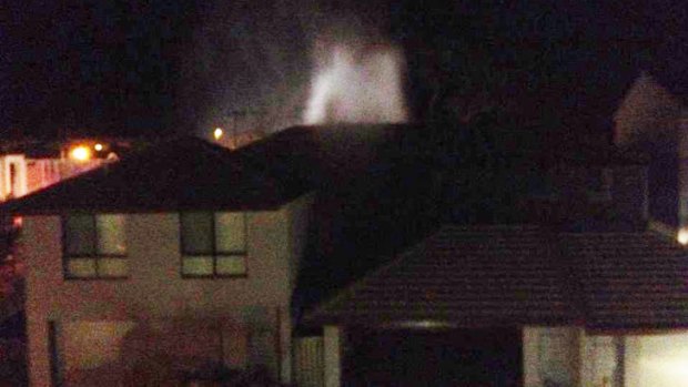 A water jet from the burst main could be seen above the roof tops of nearby houses. Photo supplied by Amy McEneny.