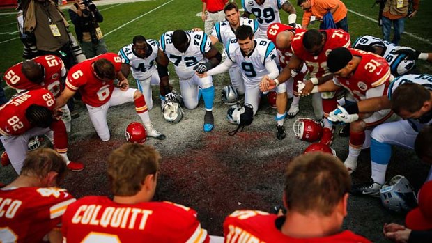 Players huddle in prayer after the Kansas City's 27-21 win over the Carolina Panthers.