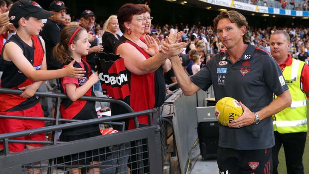 Coach James Hird slaps hands with a Bombers supporter after their win in the round one AFL NAB Cup.
