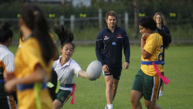 Having a ball &#8230; Australia and Waratahs winger Drew Mitchell watches as the Prairiewood High School girls show off their skills yesterday morning in Wetherill Park.