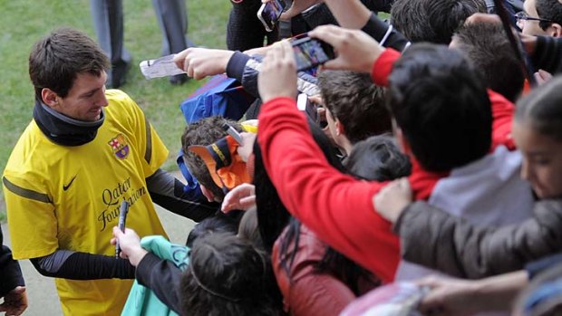 The king: Lionel Messi signs autographs for Barca fans.