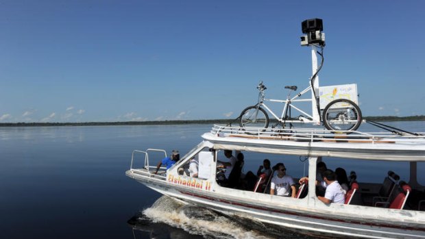 Google team members sail a boat with a 360-degree camera system mounted on a Trike on its top to record the "Street View for the Amazon" on the Negro River, around Tumbira Community, Amazonas State.