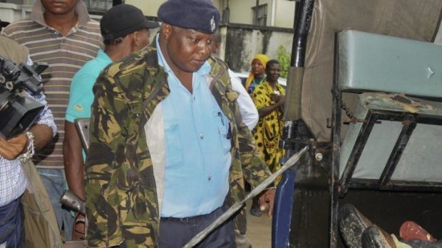 A police officer stands guard over the bodies of six attackers who military officials say were killed as they tried to gain entry to a military barracks in Mombasa on Sunday.