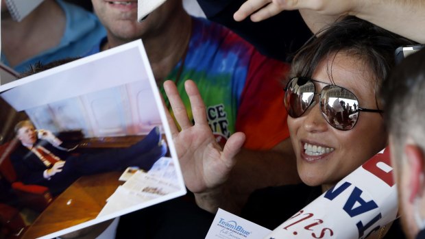 Republican Presidential candidate Donald Trump is reflected in the glasses of a supporter as he greets them and signs photographs after a campaign rally in Pittsburgh.