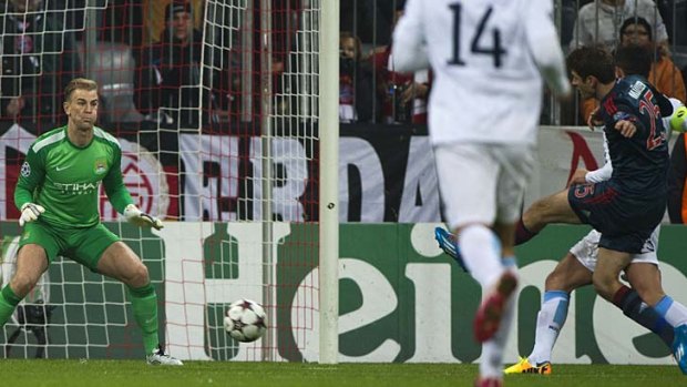 Bayern Munich midfielder Thomas Mueller scores past Manchester City goalkeeper Joe Hart.