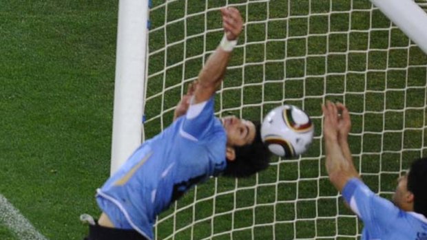 Handball ...  Luis Suarez, right, stops a certain Ghana goal.