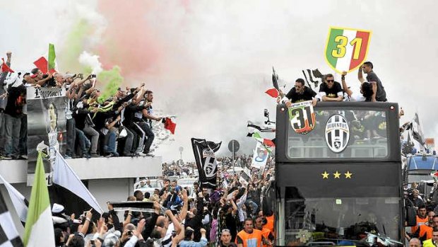 Party bus: Juventus players are mobbed as they bring the title back to Turin again, the first time in many years without Alessandro Del Piero.