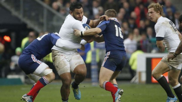 England number 8 Billy Vunipola is tackled by Antoine Burban and Jules Plisson.