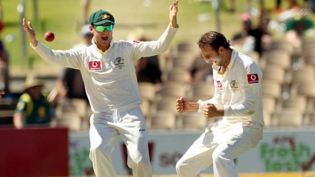 Way to go ... Nathan Lyon, right, celebrates with captain Michael Clarke after taking Sachin Tendulkar's wicket  for 25 runs yesterday.