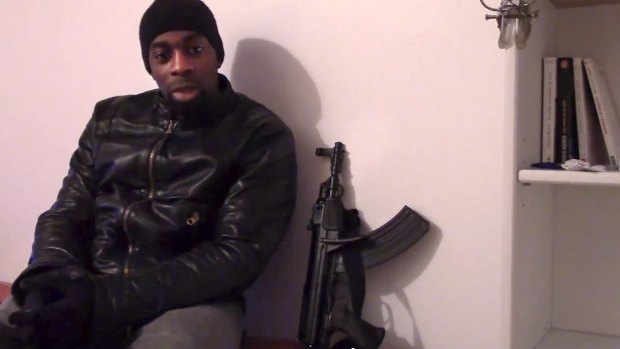 Slain hostage-taker Amedy Coulibaly, who shot a policewoman and four hostages at a kosher grocery, with a gun as he defends the Paris attacks carried out on the satirical newspaper, police and a Jewish store. 