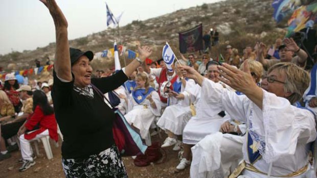 Peace in jeopardy ... supporters of Jewish settlements in the West Bank celebrate the end of a moratorium on new building.