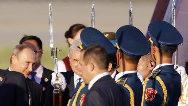 Russian President Vladimir Putin, left, arrives at the Beijing Capital International Airport in Beijing on Wednesday.