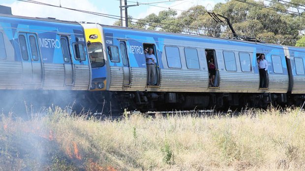 Passengers stuck on the train watch the grassfire approach.