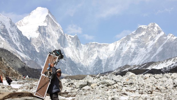 A porter, carrying crates containing oxygen tanks, climbs to Everest Base Camp in Nepal.