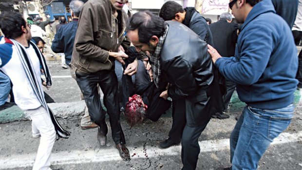 Second day of clashes ... protesters carry a man they said was shot during anti-Government protests on Enghelab Street in Tehran yesterday.