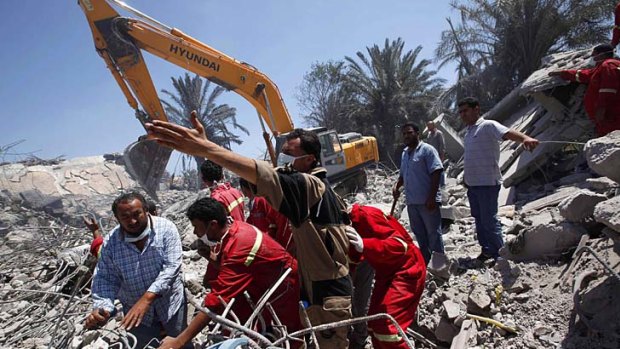 Rescue workers at a residential compound which, according to the Libyan government, had been damaged by NATO air strikes.