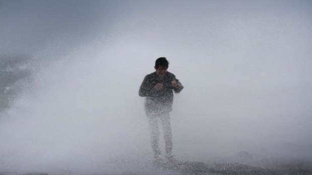 Powerful swell ... A resident stands near waves in Legazpi City, southeast of Manila as authorities warned of approaching Typhoon Rammasun.