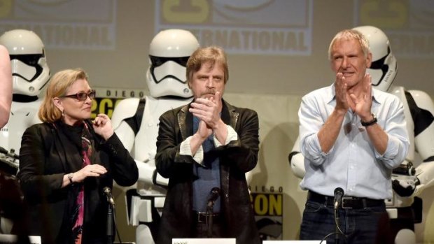 Carrie Fisher, Mark Hamill and Harrison Ford applaud onstage at the Lucasfilm panel during Comic-Con International 2015