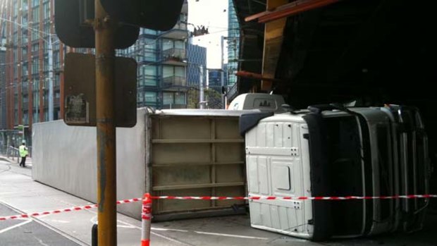 The truck lies beneath the overpass at the intersection of Spencer and Flinders Streets.