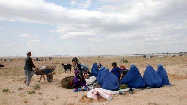 Afghan women sit on the ground after a flood in Jawzjan province in northern Afghanistan. Officials say that flooding has killed dozens of people in remote parts of the country. 