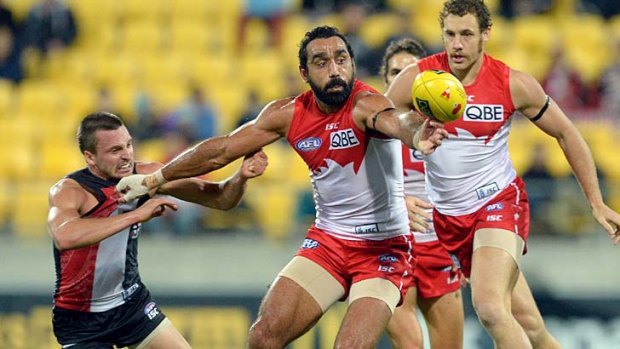 Battle for the ball: Adam Goodes keeps Jarryn Geary at bay.