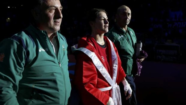On the march ... Taylor leaves the ring flanked by her father and coach, Peter (right), and trainer Zaur Anital after her victory.