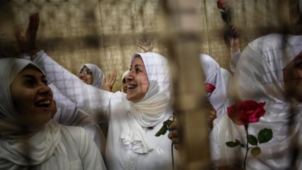 An Egyptian woman supporter of ousted President Mohammed Mursi waves from inside the defendants' cage in a courtroom in Alexandria. 