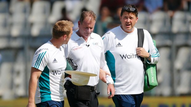 Reiffel, centre, is helped by the England team's support staff as he leaves the field for treatment.