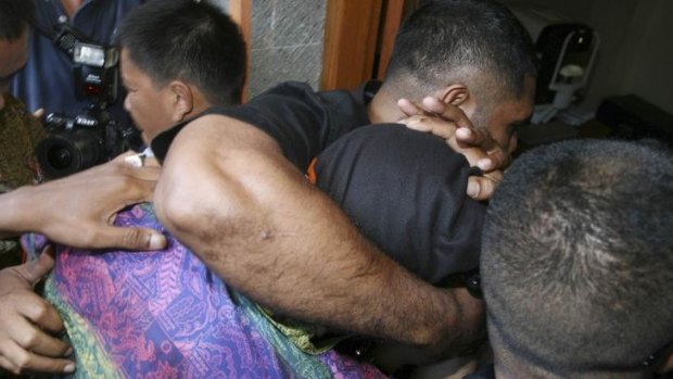 The 14-year-old  Australian boy is escorted by his bodyguards as he arrives at the Denpasar court in Bali yesterday.