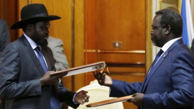 Agreement: Rebel leader Riek Machar (right) and President Salva Kiir exchange signed peace deal documents in Addis Ababa. 