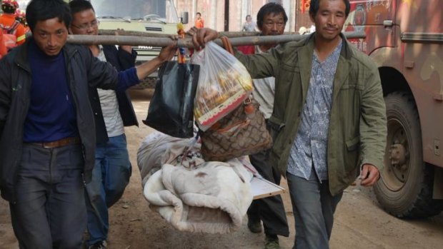 Locals carry a body out of the village of Ludian in the aftermath of the earthquake.