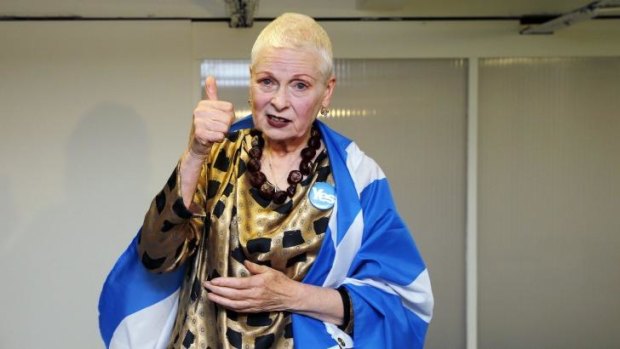 Wearing a yes badge and a Scottish flag, designer Vivienne Westwood gestures backstage before the presentation of her Vivienne Westwood Red Label spring/summer 2015 collection during London Fashion Week.