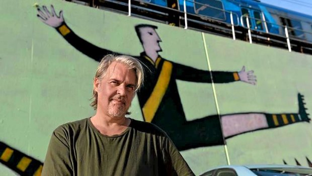 Artist Nick Howson in front of  a mural he painted next to Richmond Station, which he titled Tiger Legend.